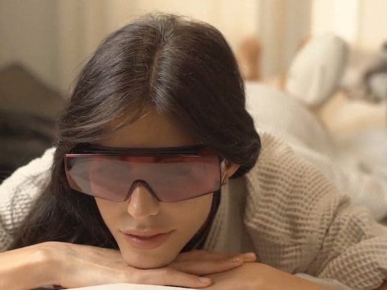 Clienta con gafas de protección láser, tumbada y tranquila antes de su sesión